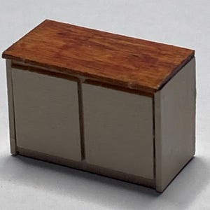 May include: A small, two-door cabinet with a wood top and white doors. The cabinet is made of wood and has a simple design.