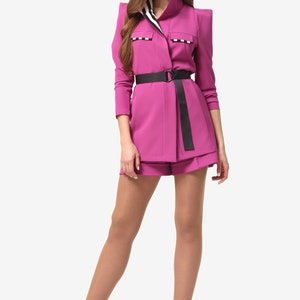 The suit consists of a jacket and shorts. The unlined jacket has a loose silhouette with relief darts and a cut-off yoke Pink
