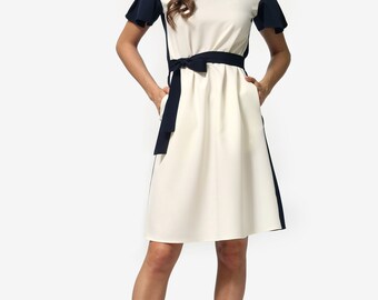 Two-tone knee-length dress with pleated sleeves and a belt made of the same fabric.