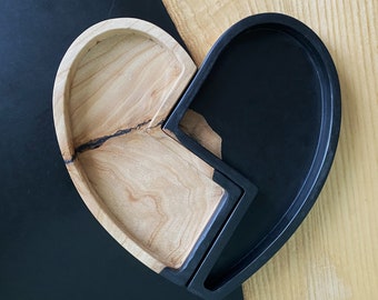 Een tweedelige hartvormige schaal gemaakt van hout en epoxyhars.