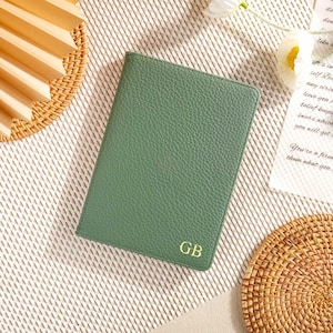 May include: A green leather notebook with the initials "GB" embossed in gold on the front cover.