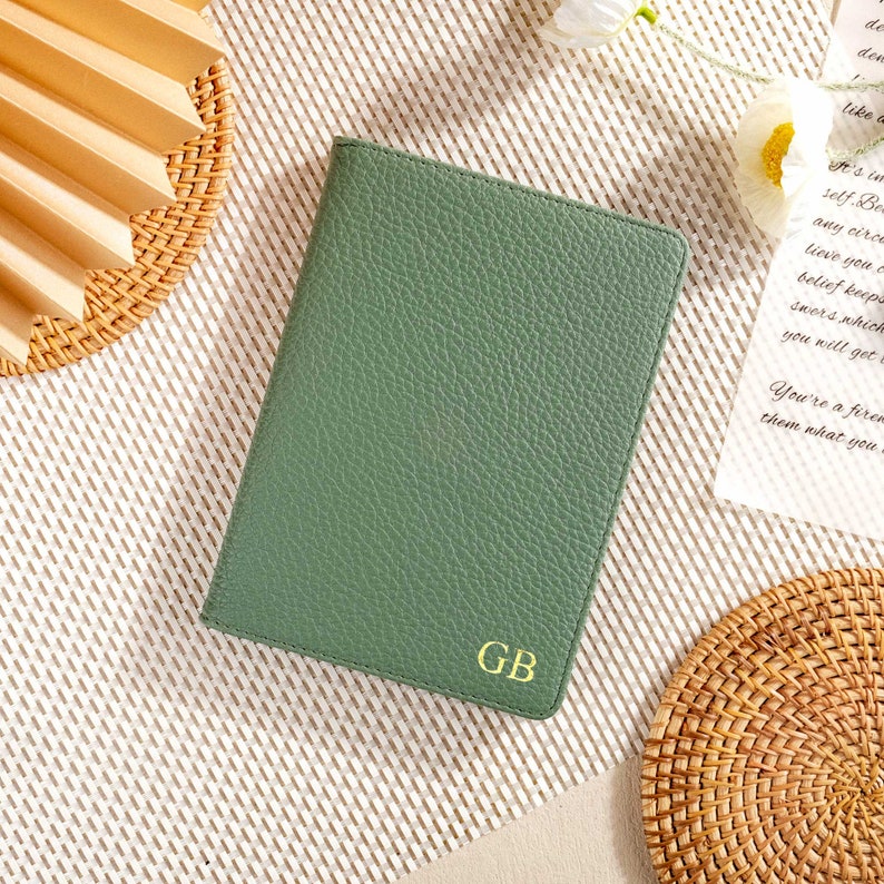 May include: A green leather notebook with the initials "GB" embossed in gold on the front cover.