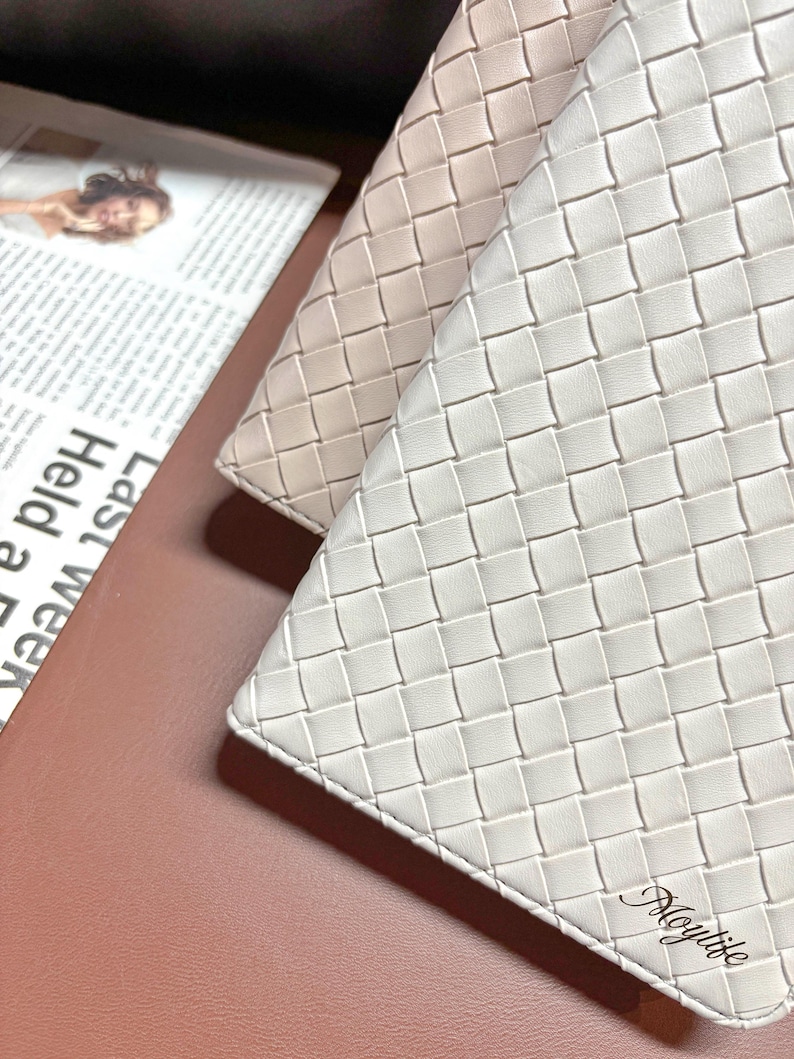 Puede incluir: Dos carteras de cuero trenzado, una de color beige claro y la otra blanca. La cartera blanca tiene la palabra "Moylite" grabada en la esquina inferior derecha.