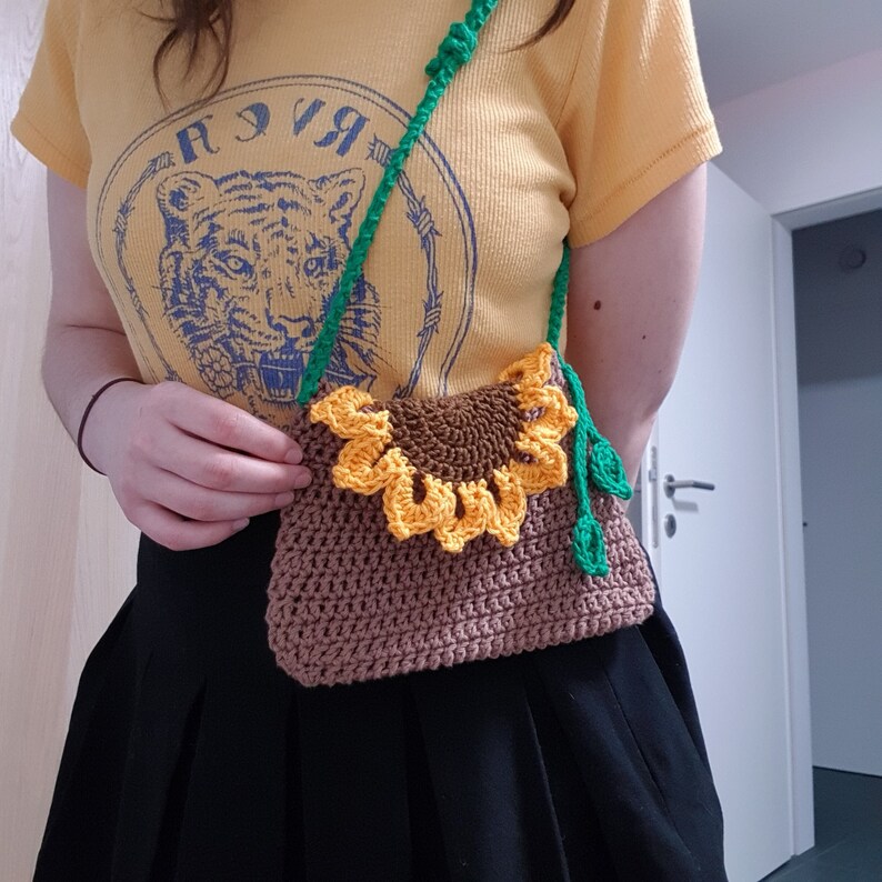 Woman wearing a crochet sunflower bag that sits at the waist