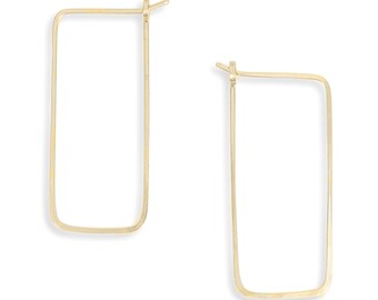 Könnte beinhalten: Ein Paar goldfarbene, rechteckige Creolen. Die Ohrringe haben ein schlichtes, minimalistisches Design mit rechteckiger Form. Sie bestehen aus dünnem, goldfarbenem Metall und haben einen Hakenverschluss.