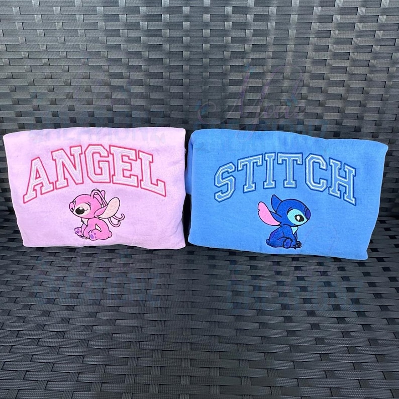Puede incluir: Dos camisas azules y rosas con las palabras "Angel" y "Stitch" impresas en ellas. Cada camisa presenta un personaje de dibujos animados, un Stitch rosa con alas y un Stitch azul con alas.