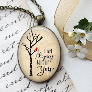 May include: A glass pendant necklace with a bronze chain. The pendant features a vintage-style image of a tree with a red cardinal perched on a branch. The text "I AM ALWAYS WITH YOU" is printed on the pendant.