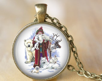 May include: A round pendant necklace with a bronze-colored chain. The pendant features a colorful illustration of Santa Claus surrounded by various arctic animals, including a polar bear, reindeer, and wolf. The pendant has a vintage, antique style.