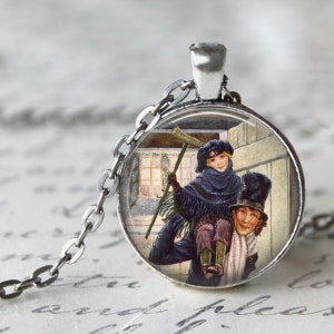 K&ouml;nnte beinhalten: Eine silberfarbene Halskette mit Anh&auml;nger, die einen runden Charm mit einer Vintage-Illustration zeigt. Die Illustration zeigt zwei Figuren in Winterkleidung, von denen eine die andere tr&auml;gt. Der Charm h&auml;ngt an einer feinen Kette.