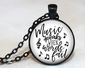 May include: Black necklace with a round glass pendant featuring the text "Music speaks when words fail" and musical notes.