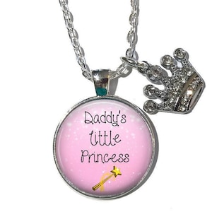 May include: A silver necklace with a pink round pendant that says "Daddy's little princess" with a gold glitter background and a gold glitter wand. The necklace also has a silver crown charm with clear rhinestones.