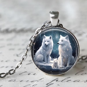 May include: A silver necklace with a round glass pendant featuring a white wolf family. The wolves are depicted in a snowy forest setting with a starry sky.