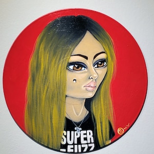 May include: A painting of a woman with long blonde hair wearing a black shirt with the words "SUPER -EII77" on it. The background is red.