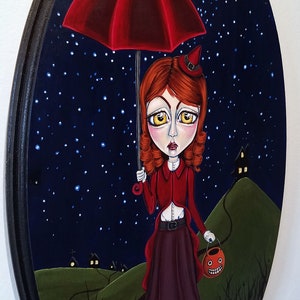 K&ouml;nnte beinhalten: Ein M&auml;dchen in einem roten Kleid und einer Hexenm&uuml;tze geht unter einem roten Regenschirm durch einen dunklen Wald. Sie tr&auml;gt eine K&uuml;rbislaterne und ist von Sternen und einem Halbmond umgeben.