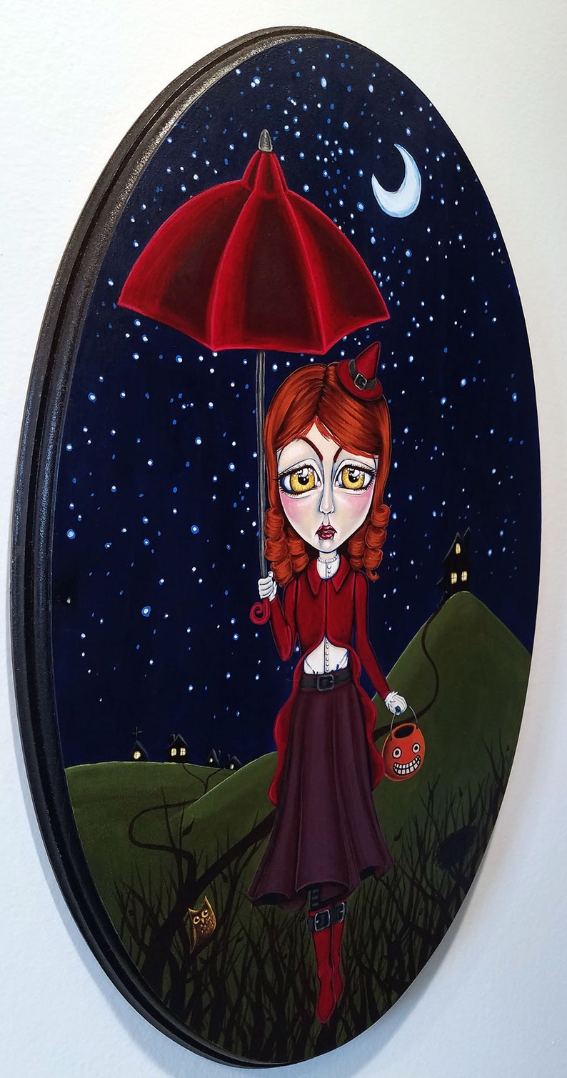 K&ouml;nnte beinhalten: Ein M&auml;dchen in einem roten Kleid und einer Hexenm&uuml;tze geht unter einem roten Regenschirm durch einen dunklen Wald. Sie tr&auml;gt eine K&uuml;rbislaterne und ist von Sternen und einem Halbmond umgeben.