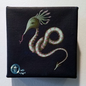 May include: A small painting on canvas of a green and pink striped creature with a long, thin neck and a pointed tail. The creature has a crown of pink and green spikes on its head. The background is black.