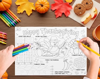 May include: Thanksgiving-themed activity placemat with the text "Happy Thanksgiving". The placemat features a turkey, pumpkins, and fall leaves. Includes coloring and activity sections. Colored pencils and pumpkins are on the wooden surface.