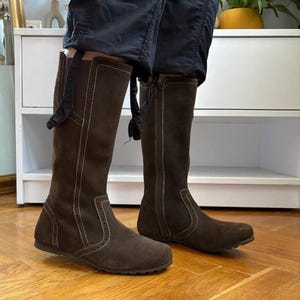 Botas altas de ante marrón TMK Boots con detalle de costuras brogue, suela de cuña y cierre de cremallera.