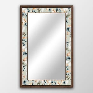May include: A rectangular mirror with a brown wooden frame and a floral design border. The floral design features blue and orange watercolour leaves on a light green background.