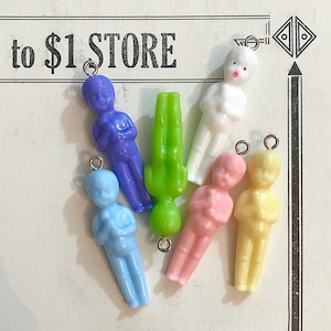 May include: Seven plastic figurines of people with arms crossed, each in a different color: light blue, blue, green, pink, yellow, white, and light pink. The figurines are hanging from silver jump rings.