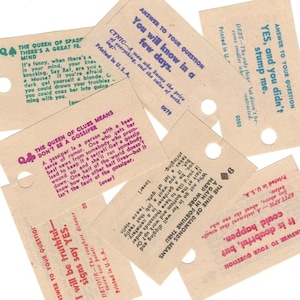 May include: A collection of vintage game cards with various questions and answers. The cards are printed on brown paper with black and pink text. The cards feature a variety of topics, including gossip, money, and hard work.
