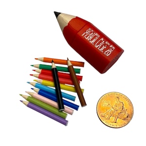 May include: A red pencil-shaped container with the text "PENCIL CASE 26" and a collection of colorful pencils. A US one-cent coin is also visible.