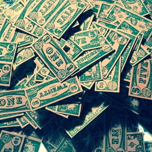 May include: A pile of green and white paper game cards with various denominations, including "One", "Five", "Twenty", "Fifty", and "One Hundred".