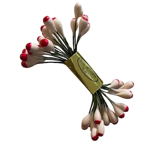 May include: A bundle of artificial flower stamens. Each stamen has a white, teardrop-shaped head with a bright red tip. The green stems are bound together with a gold label that reads "MADE IN TAIWAN R.O.C."