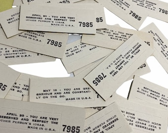 May include: A pile of vintage paper fortune telling cards with the text "You are very reserved and respect the other person's ideas. Made in U.S.A." and "You are great, various and are constantly on the go. Made in U.S.A."