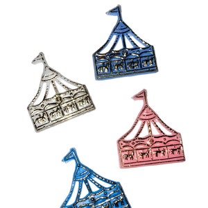May include: Four miniature carousel tent charms in blue, pink, silver, and gold. The charms are made of metal and have a detailed design.