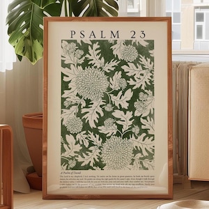 Peut inclure: Une affiche encadrée avec le texte "Psalm 23" en haut, au-dessus d'un motif floral vert et crème. L'affiche comprend également le texte "A Psalm of David" et d'autres écritures en bas. Le cadre est en bois brun clair.