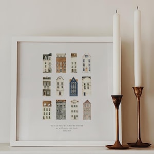 May include: A framed print with a white background and a watercolour illustration of 12 small houses in various colours. The text "BUT AS FOR ME AND MY HOUSE we will serve the Lord. Joshua 24:15" is printed below the houses.