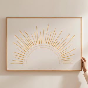 Può includere: Una stampa incorniciata con un design a raggi di sole gialli stilizzati su sfondo crema. Il sole irradia da un semicerchio con testo. La cornice è in legno chiaro. Il testo recita: "Il Signore ti benedica e ti custodisca; il Signore faccia risplendere per te la sua faccia e ti sia propizio."
