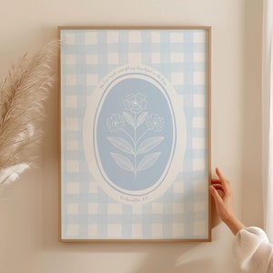 May include: A framed art print featuring a light blue gingham pattern background. A light blue oval in the center displays a white floral illustration with the text "He has made everything beautiful in its time. Ecclesiastes 3:11."