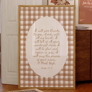 May include: A brown and white gingham print wall art with a white oval containing a bible verse from Psalm 9:1-2. The text reads "I will give thanks to you, Lord, with all my heart; I will tell of all your wonderful deeds. I will be glad and rejoice in you; I will sing the praises of your name, O Most High. Psalm 9:1-2"