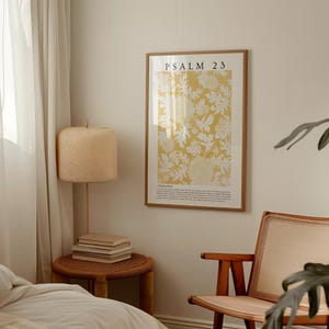 May include: A framed print with a yellow background and white floral design. The print has the text "PSALM 23" at the top and a passage of text below the floral design.