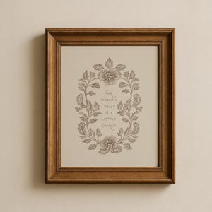 Peut inclure: Une impression encadrée avec un motif de couronne florale et le texte "For indeed, a house is a little church." Le cadre est de couleur marron chaud, et l'impression a un fond neutre.