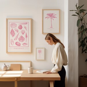 Puede incluir: Una impresi&oacute;n enmarcada con una ilustraci&oacute;n rosa de conchas marinas y el texto "PSALM 104:25". La impresi&oacute;n est&aacute; colgada en una pared blanca junto a una impresi&oacute;n enmarcada con una ilustraci&oacute;n rosa de una palmera y el texto "Gracias por la palmera".