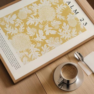 May include: A framed print with a yellow background and white floral pattern. The print includes the text "ALM 23" and a verse from Psalm 23.