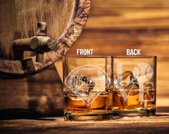 May include: Two square whiskey glasses with ice and amber liquid. One glass has a baseball-themed logo with the text "Pirates". The other glass has the word "LOVE" and a baseball graphic. The glasses are on a wooden surface.