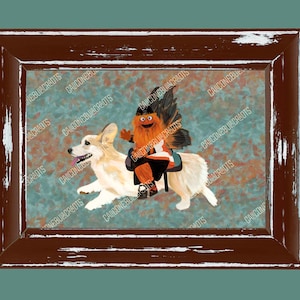 Könnte beinhalten: Ein rechteckiger, brauner Rahmen aus abgenutztem Holz mit einer Illustration eines hellen Corgi-Hundes, auf dessen Rücken eine kleine, orangefarbene, pelzige Kreatur mit schwarzen Flügeln sitzt. Der Hintergrund zeigt ein blau-braunes Muster.