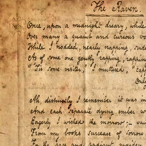 May include: A close-up of a handwritten page from a book titled "The Raven". The page is yellowed and has a worn, aged appearance. The text is written in cursive script and includes the first lines of the poem "The Raven" by Edgar Allan Poe.