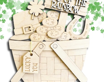 May include: A wooden basket overflowing with St. Patrick's Day themed cutouts. Includes a leprechaun hat, shamrocks, gold coins, and a horseshoe. The sign reads "END OF THE RAINBOW" and a tag says "LUCKY YOU".