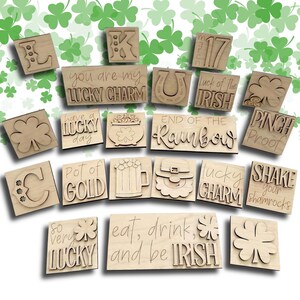 May include: A collection of wooden St. Patrick's Day themed cutouts. The cutouts include phrases like "Lucky Charm", "Pot of Gold", and "End of the Rainbow", along with shamrocks, a horseshoe, and a leprechaun hat. The cutouts are made of light-colored wood.