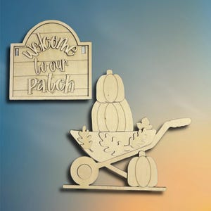 May include: Two wooden fall-themed decorations. One is a sign that reads "Welcome to our Patch". The other is a wheelbarrow with pumpkins and fall leaves. Both are made of unfinished wood.