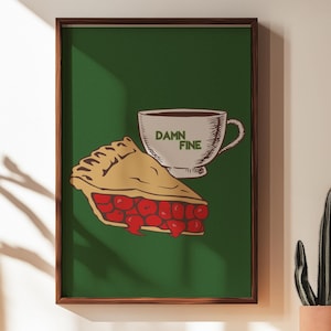 May include: Framed art print with a green background, depicting a slice of cherry pie and a coffee cup. The pie has a golden crust and red filling. The cup is white with the words "Damn Fine".