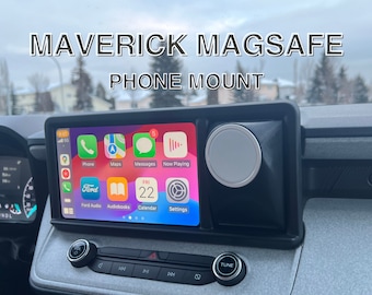 Puede incluir: Soporte de teléfono negro con cargador MagSafe, instalado en un vehículo. El teléfono muestra una pantalla de aplicaciones colorida. El texto en el soporte dice "MAVERICK MAGSAFE PHONE MOUNT."
