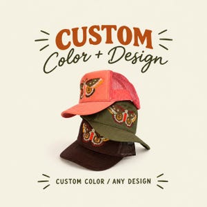 May include: Three stacked trucker hats in coral, olive green, and dark brown, each featuring a pixelated butterfly embroidery. The text CUSTOM Color + Design and CUSTOM COLOR / ANY DESIGN is displayed above and below the hats in a bold font.