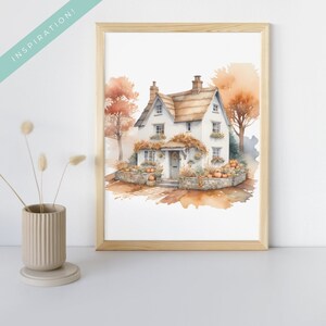 May include: A watercolor painting of a white cottage with a thatched roof, surrounded by fall foliage and pumpkins. The cottage has a gray door and windows, and a wreath on the door.