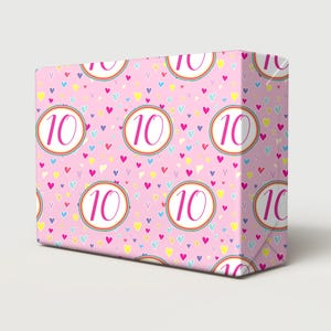 May include: Pink wrapping paper with a repeating pattern of colorful hearts and the number "10" in a pink circle.